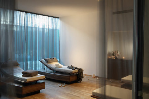two lounge chairs mounted on wooden platforms. They are adjustable for the angle that is most comfortable. There is a reading light next to the chairs. Each chair has a blanket and pillow.