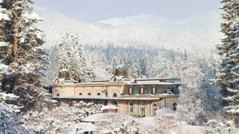 post card like beautiful winter scene of the Belle Epoque pavilion surrounded by snow covered trees and mountains, blue sky in the background
